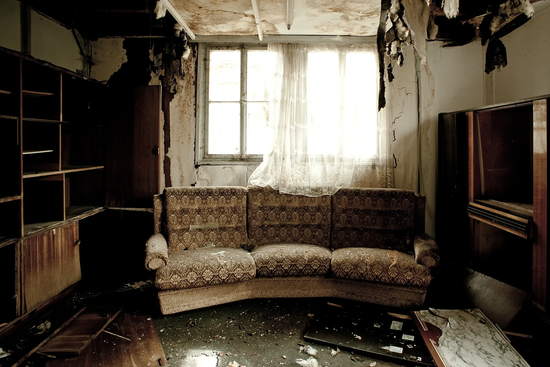 A family's living room after a devastating fire, now being restored by a professional property restoration company. The team is dedicated to bringing the property back to its pre-fire state